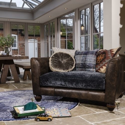 Compact leather snuggler chair with textured cushions in a bright garden room